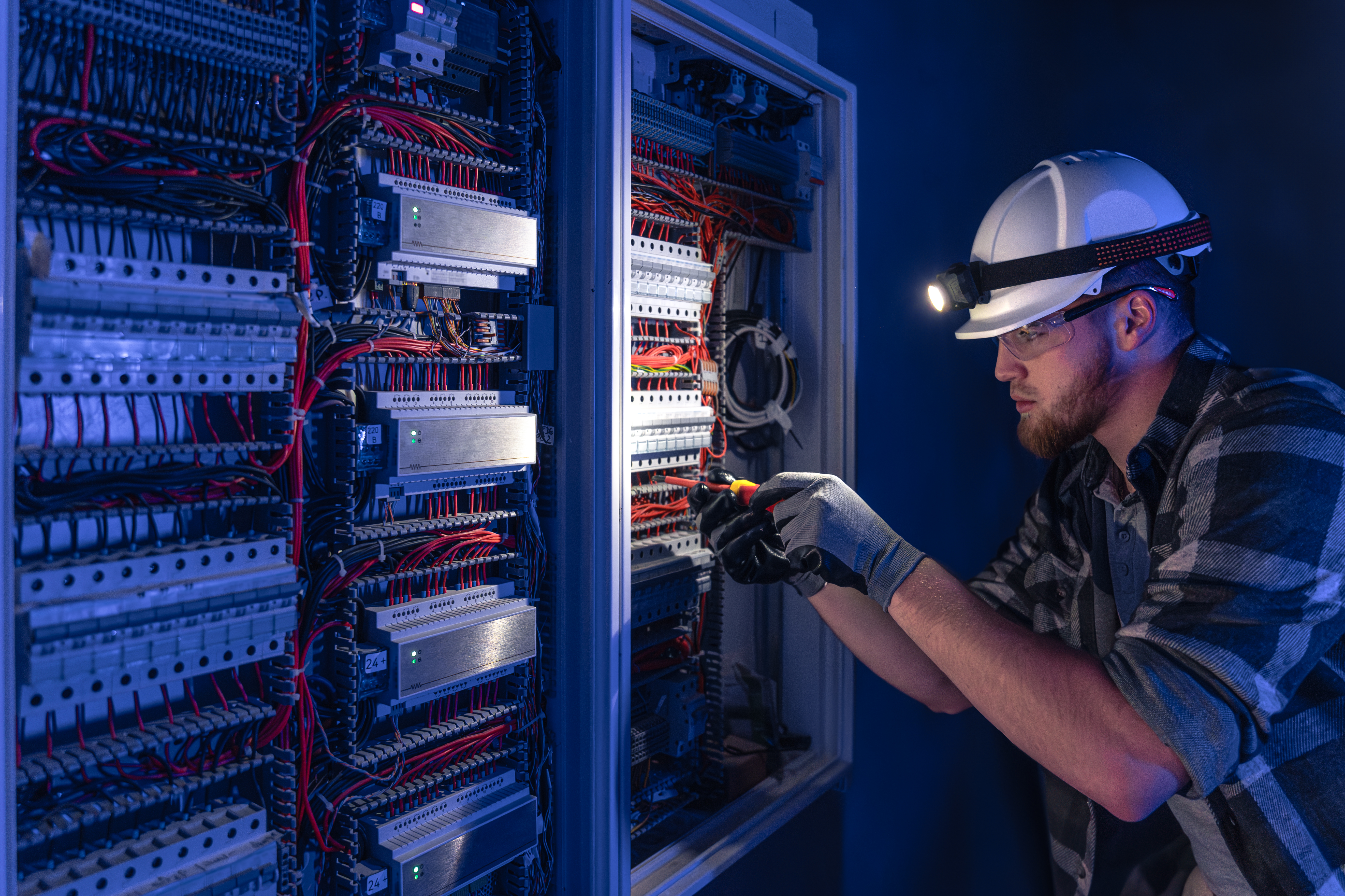 Licensed electrician working on a commercial electrical panel